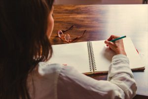 Escritor mirando una hoja en blanco mientras intenta superar el bloqueo creativo
